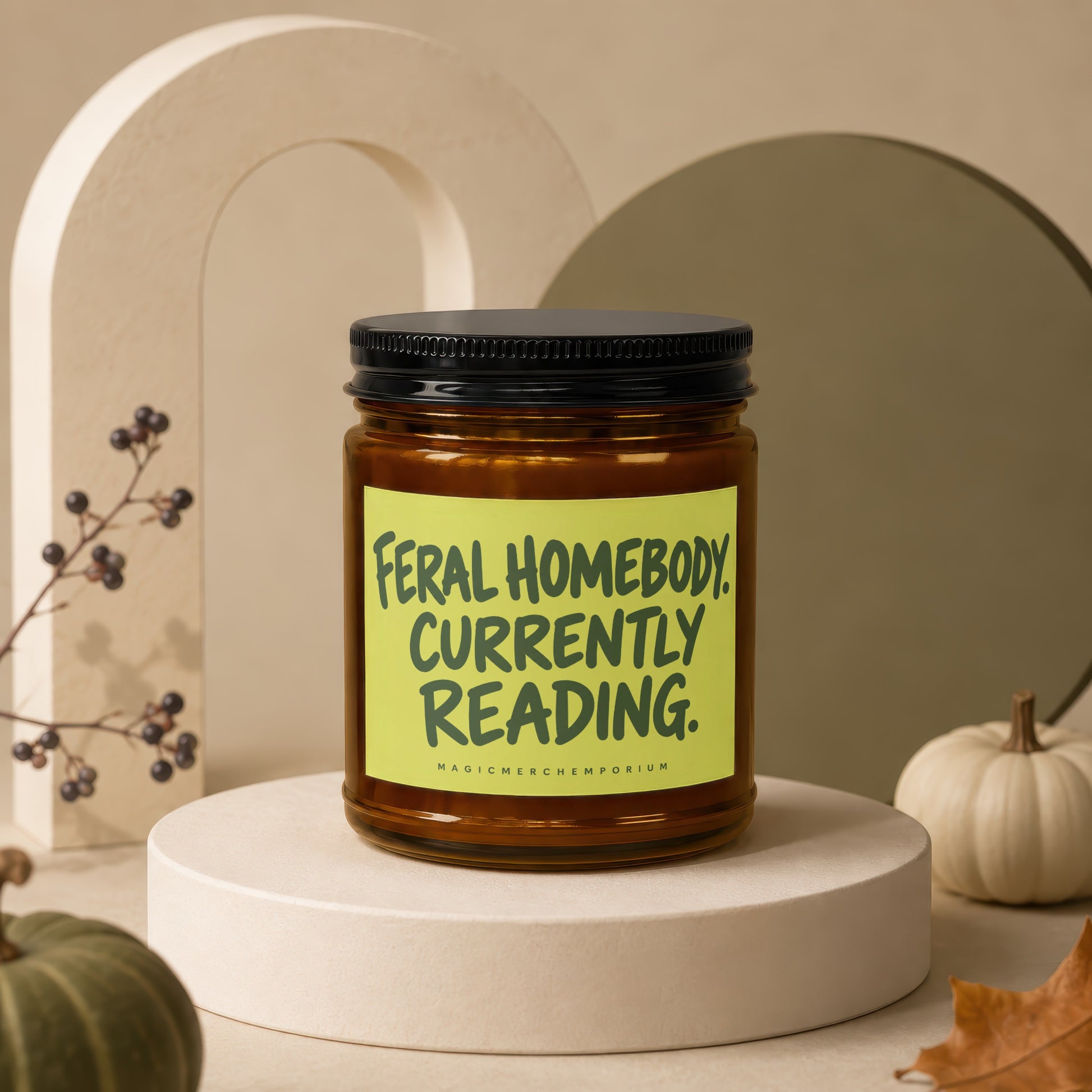 Amber jar candle with black lid and lime green label reading "FerAl HOMEBODY. CURRENTLY READING."