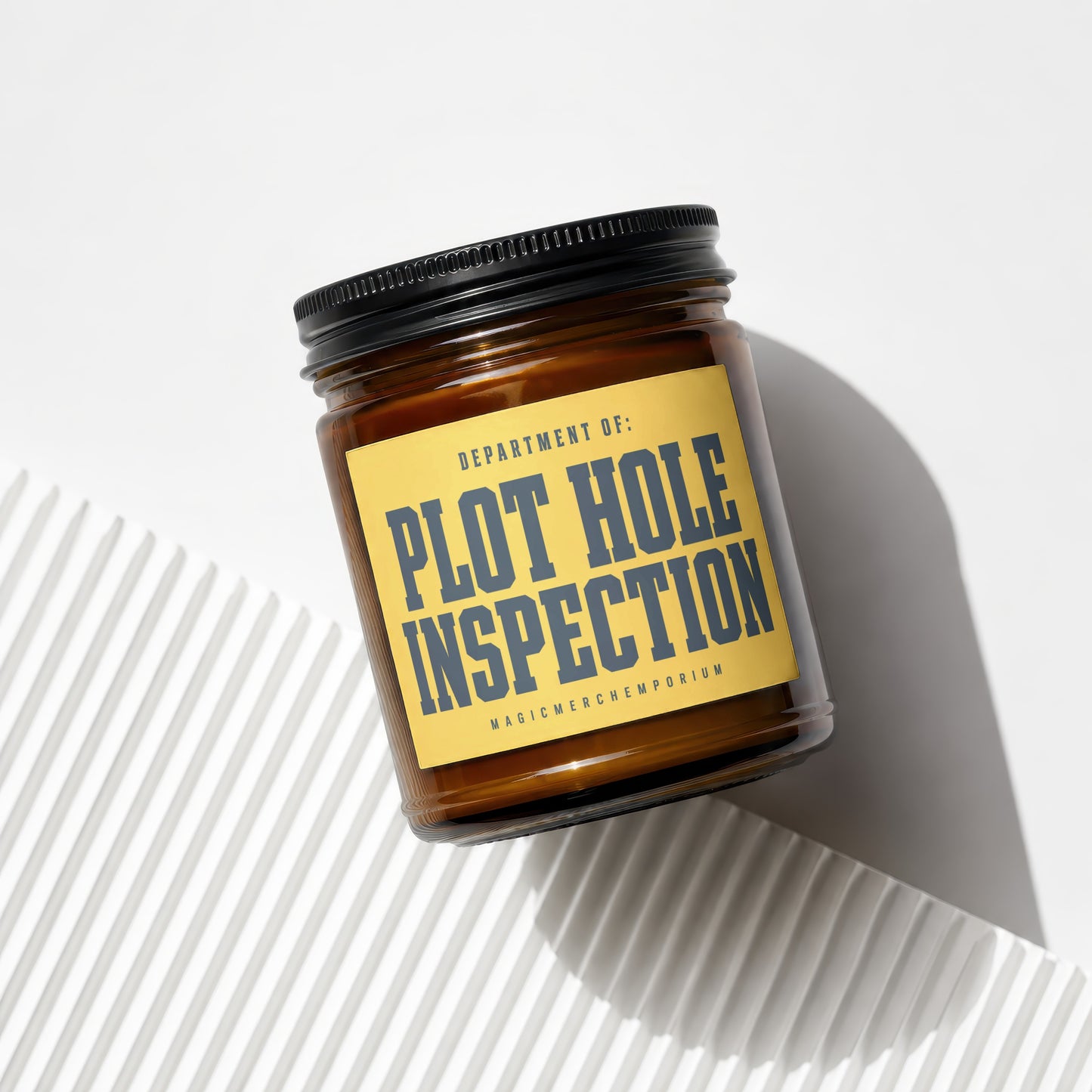 Amber jar candle labeled "Department of: Plot Hole Inspection" and "Magic Merch Emporium"