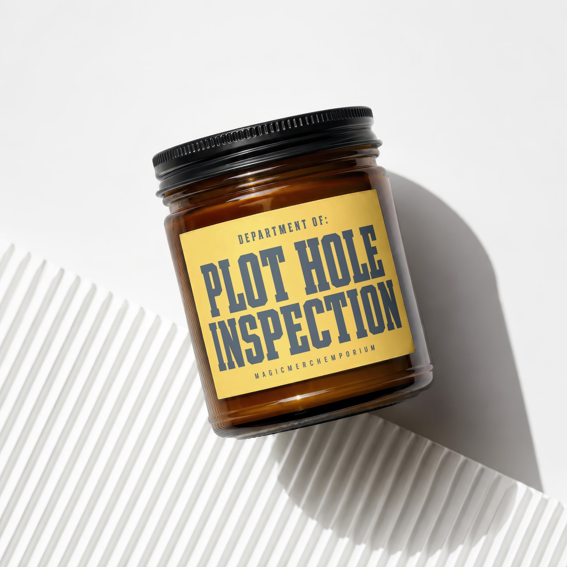 Amber jar candle labeled "Department of: Plot Hole Inspection" and "Magic Merch Emporium"