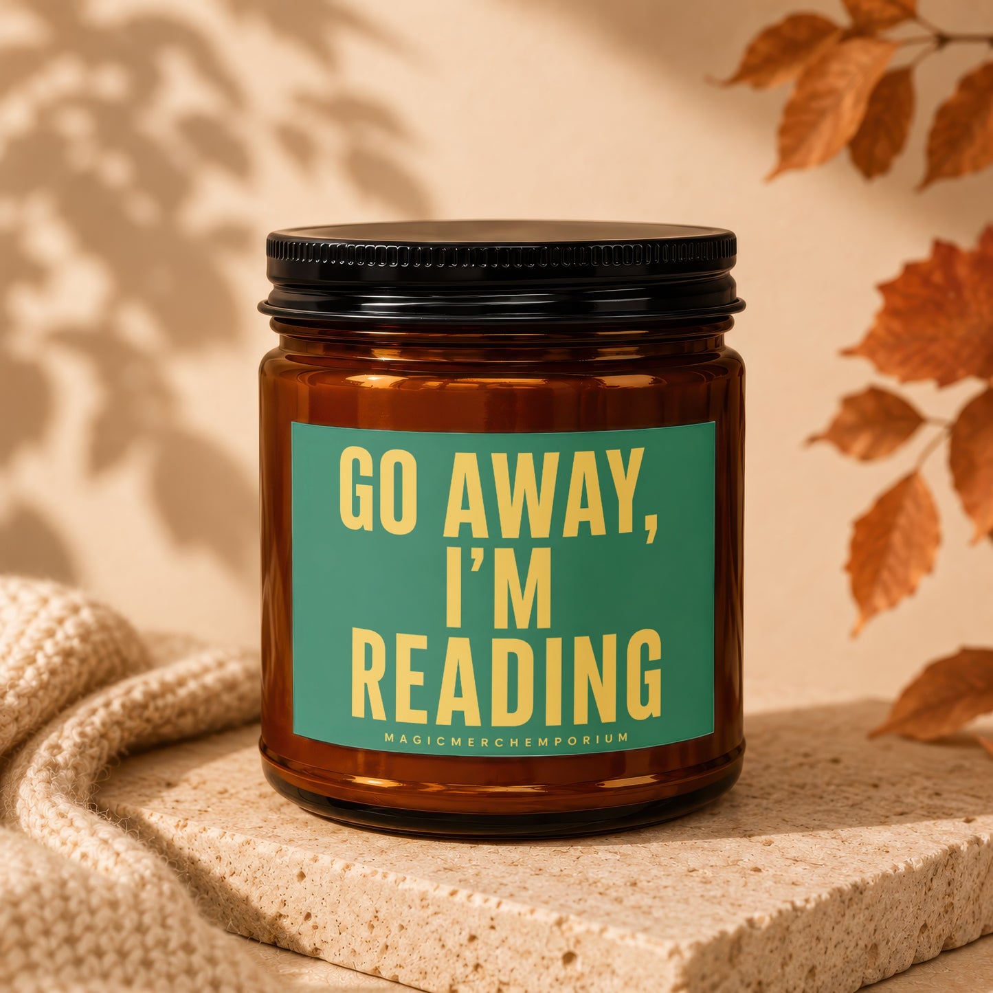 Amber glass candle with green label reading "GO AWAY, I'M READING".