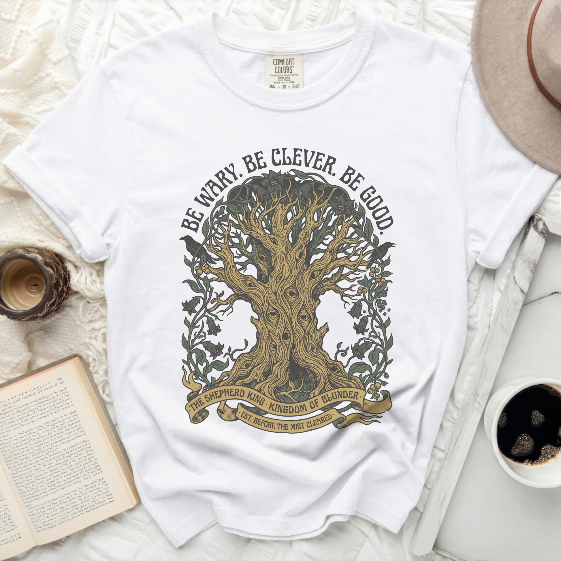 White t-shirt with a tree graphic and "Be Wary. Be Clever. Be Good." text.