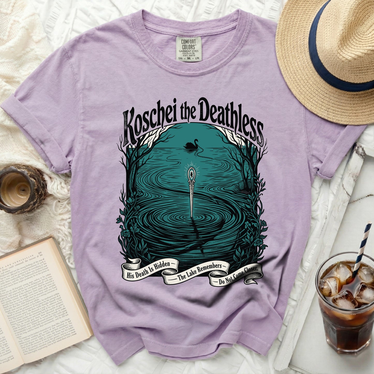 Purple t-shirt with "Koschei the Deathless" and lake scene graphic.