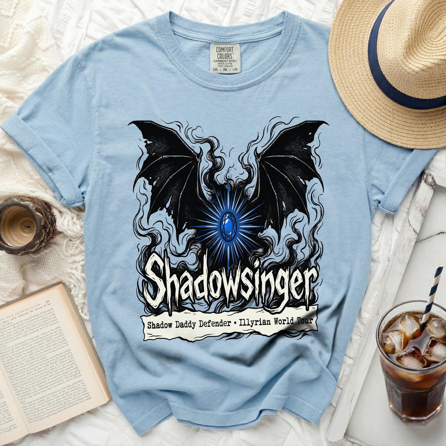 Light blue t-shirt with a black winged creature and "Shadowsinger" text.