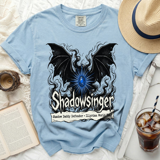 Light blue t-shirt with a black winged creature and "Shadowsinger" text.
