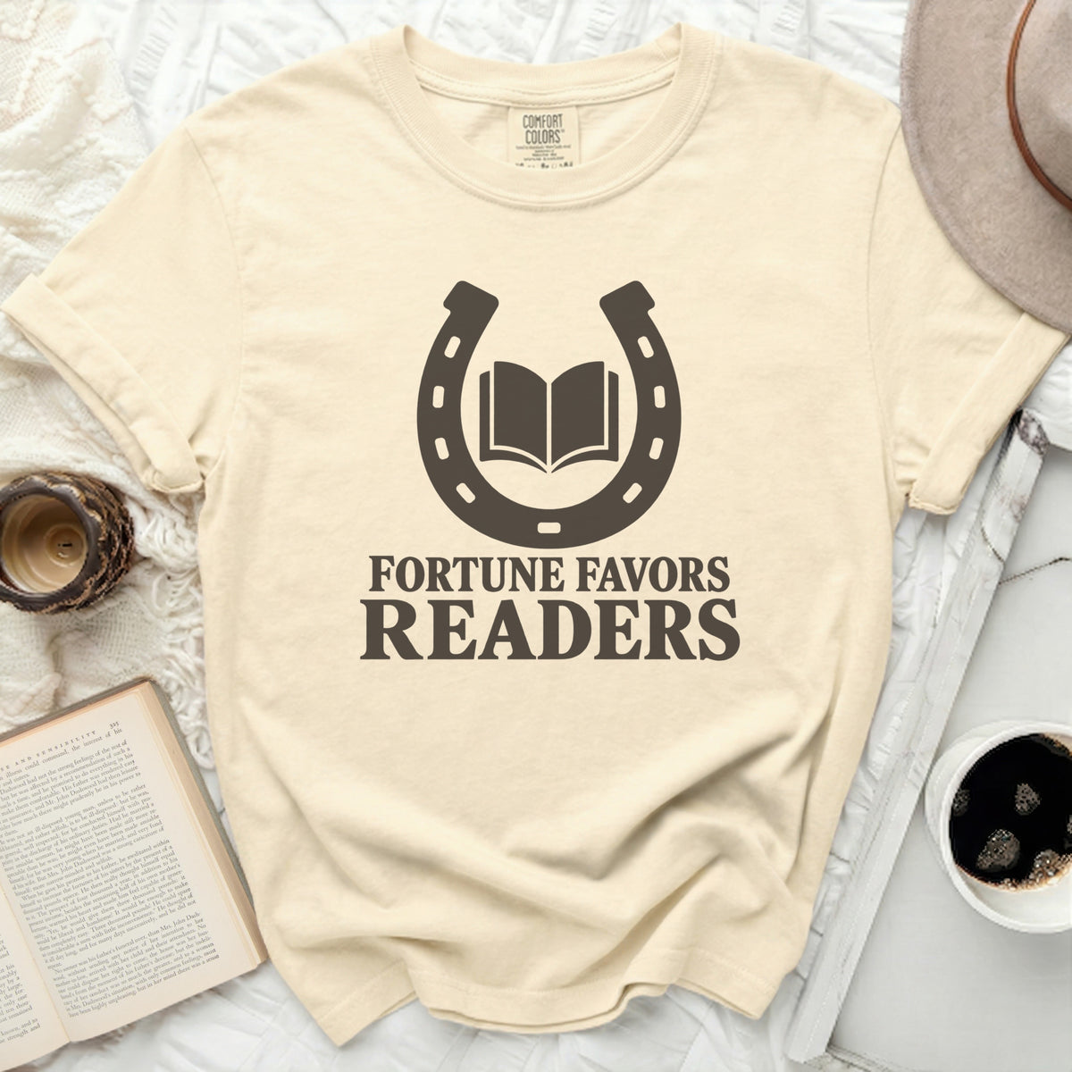 Cream t-shirt with "Fortune Favors Readers" and a horseshoe with a book.
