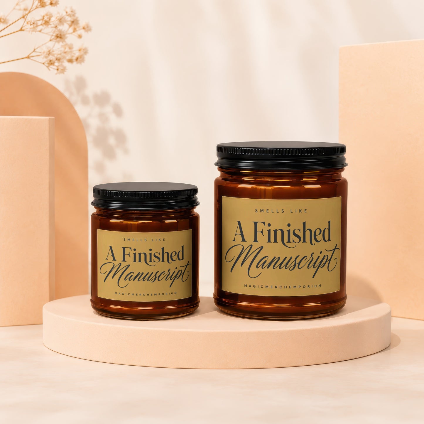 Two amber glass candles with black lids and "A Finished Manuscript" labels.