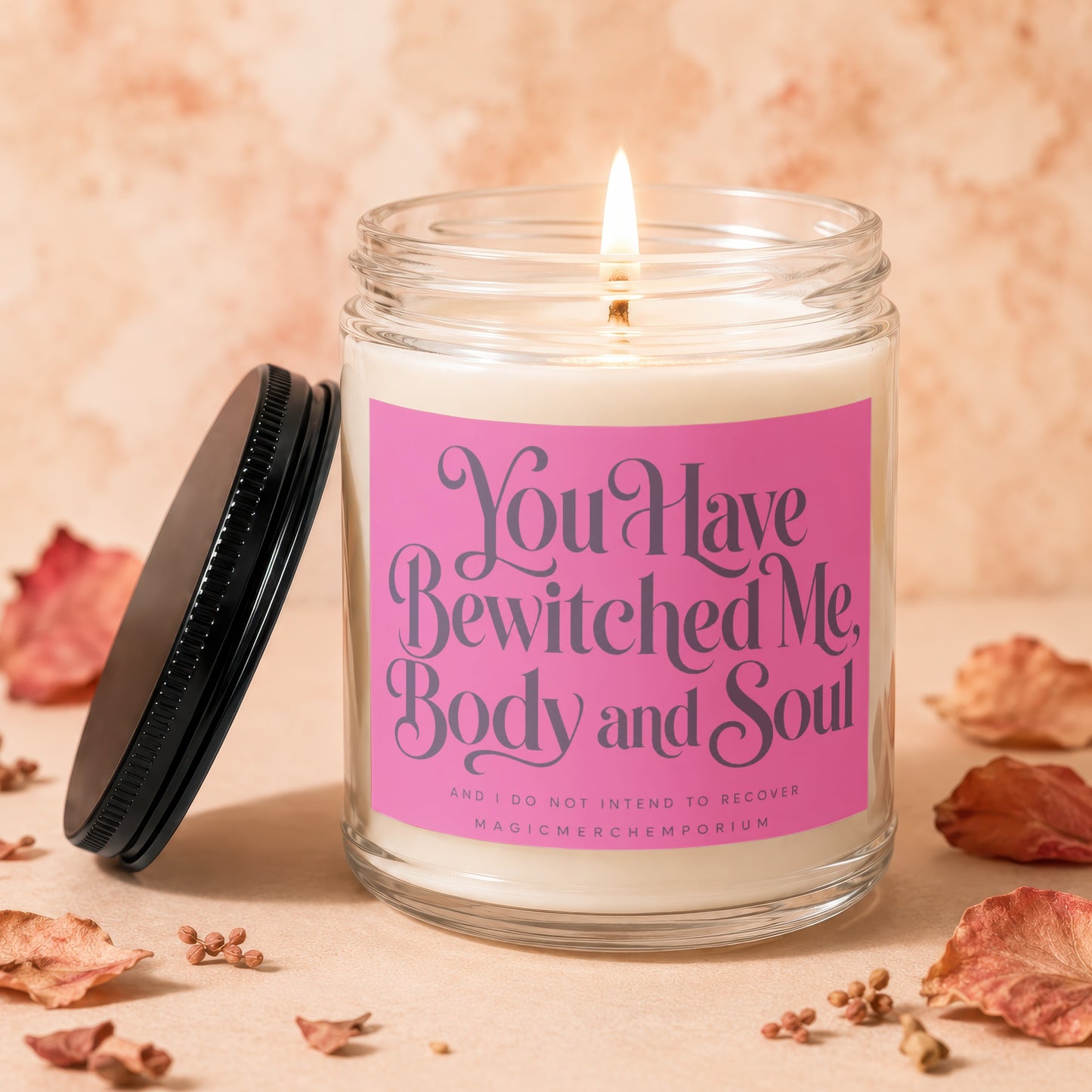 Glass candle with pink label reading "You Have Bewitched Me, Body and Soul".