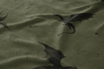 Dark green fabric with a pattern of black dragons and scattered constellations.