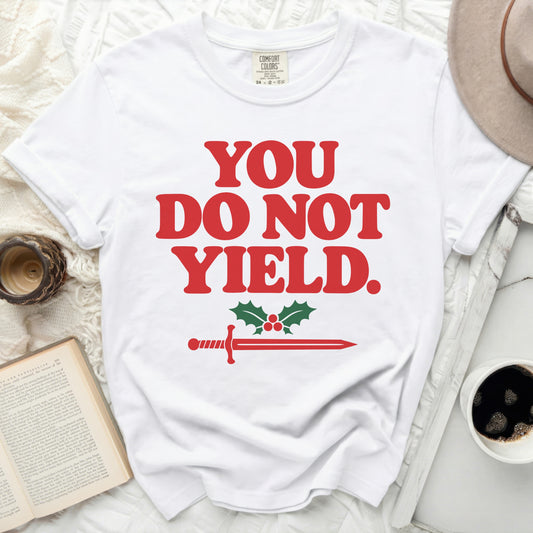 White t-shirt with red text "YOU DO NOT YIELD" and a sword with holly.