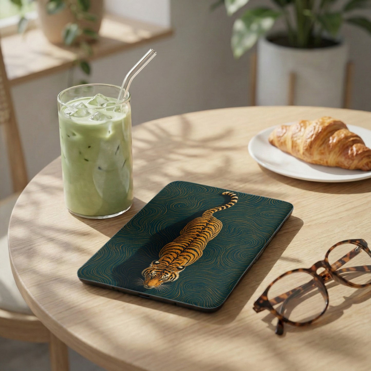 Tablet with tiger illustration and wave pattern on a wooden table.