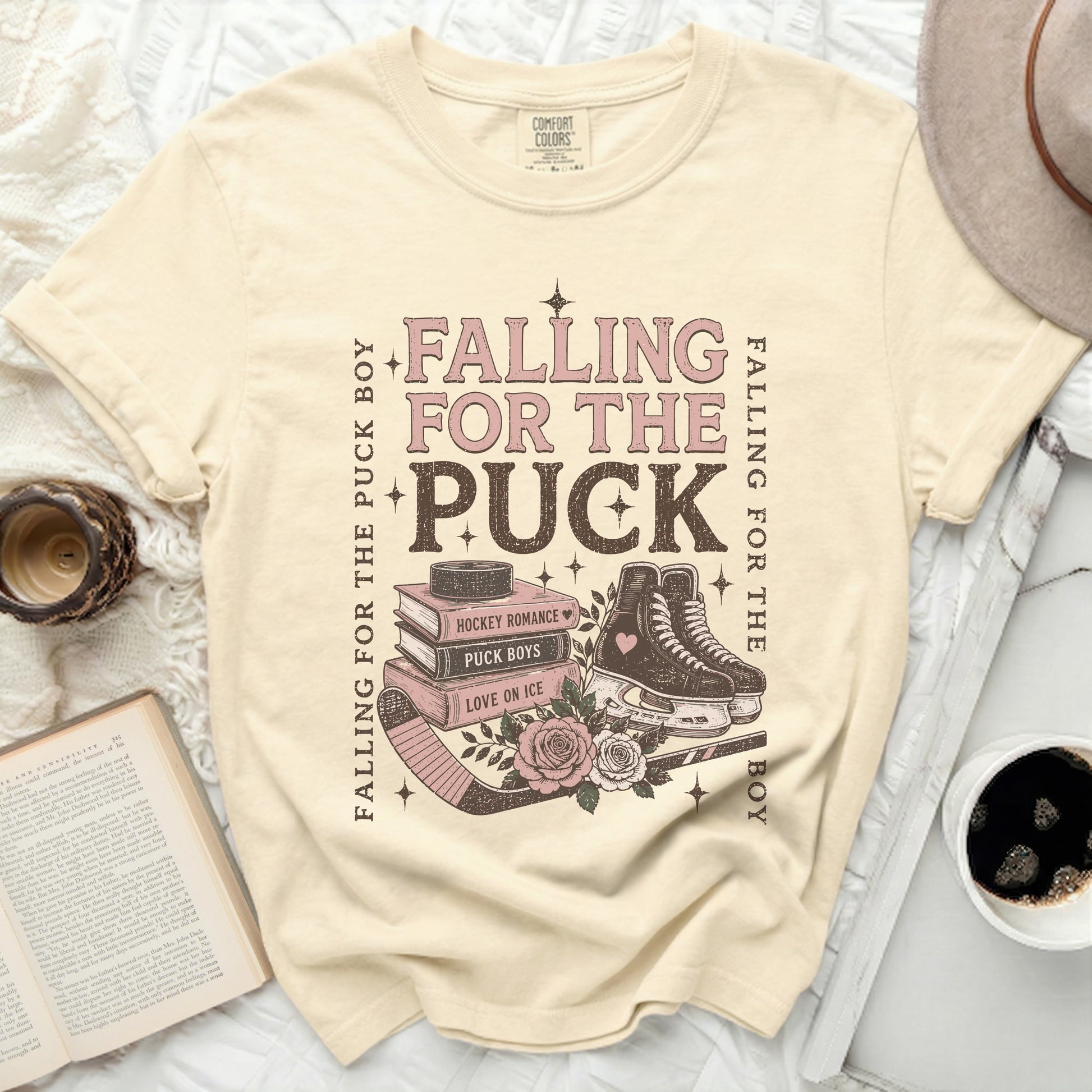 Cream t-shirt with "Falling for the Puck Boy" hockey romance graphic.