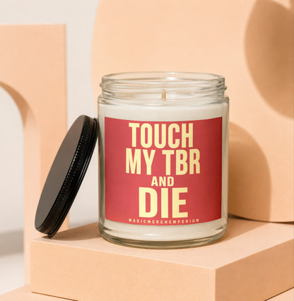 Glass candle with red label saying "TOUCH MY TBR AND DIE"