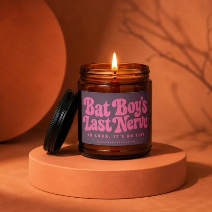 Burning amber glass candle with purple label reading "Bat Boy's Last Nerve".