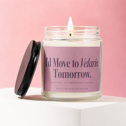 Glass candle with lit wick and purple label reading "I'd Move to Velaris Tomorrow."