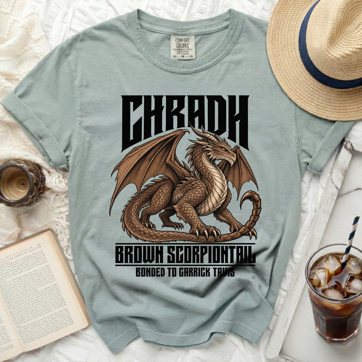 Light blue t-shirt with dragon and text CHRADH, BROWN SCORPIONTAIL, BONDED TO GARRICK TAVIS.