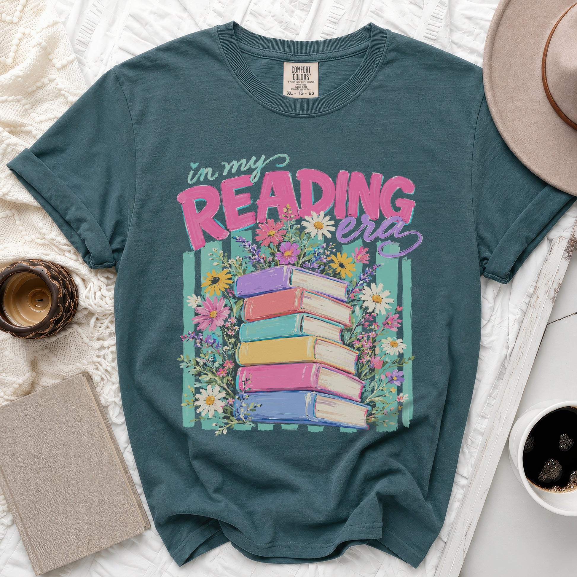 Teal t-shirt with "in my READING era" text and stacked books with flowers.