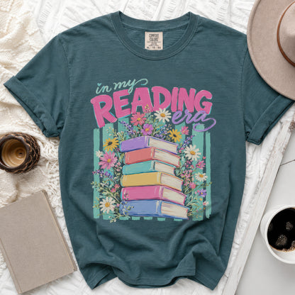 Teal t-shirt with "in my READING era" text and stacked books with flowers.