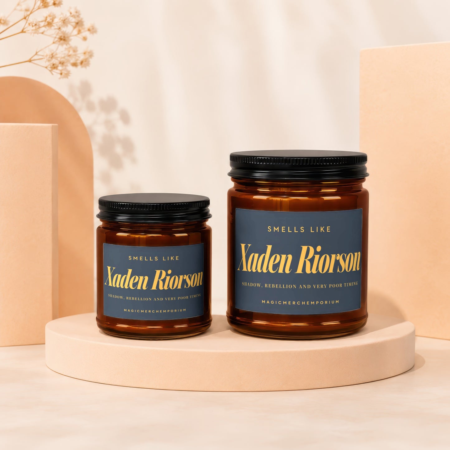 Two brown glass candles labeled "Xaden Riorson" with gold text.