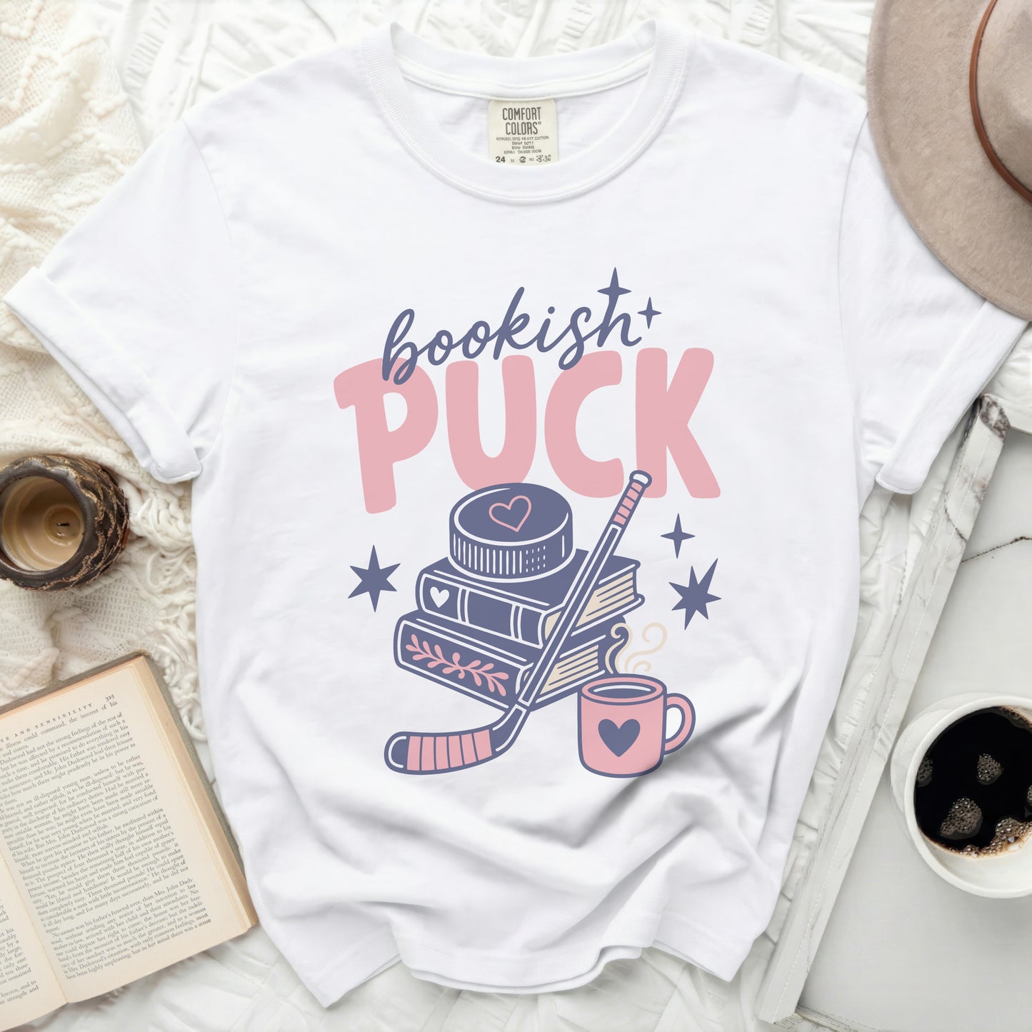 White t-shirt with "Bookish Puck" text, books, hockey stick, and mug graphic.