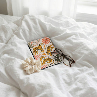 Coaster with tigers and tropical leaves pattern, scrunchie, and glasses on white bedding.