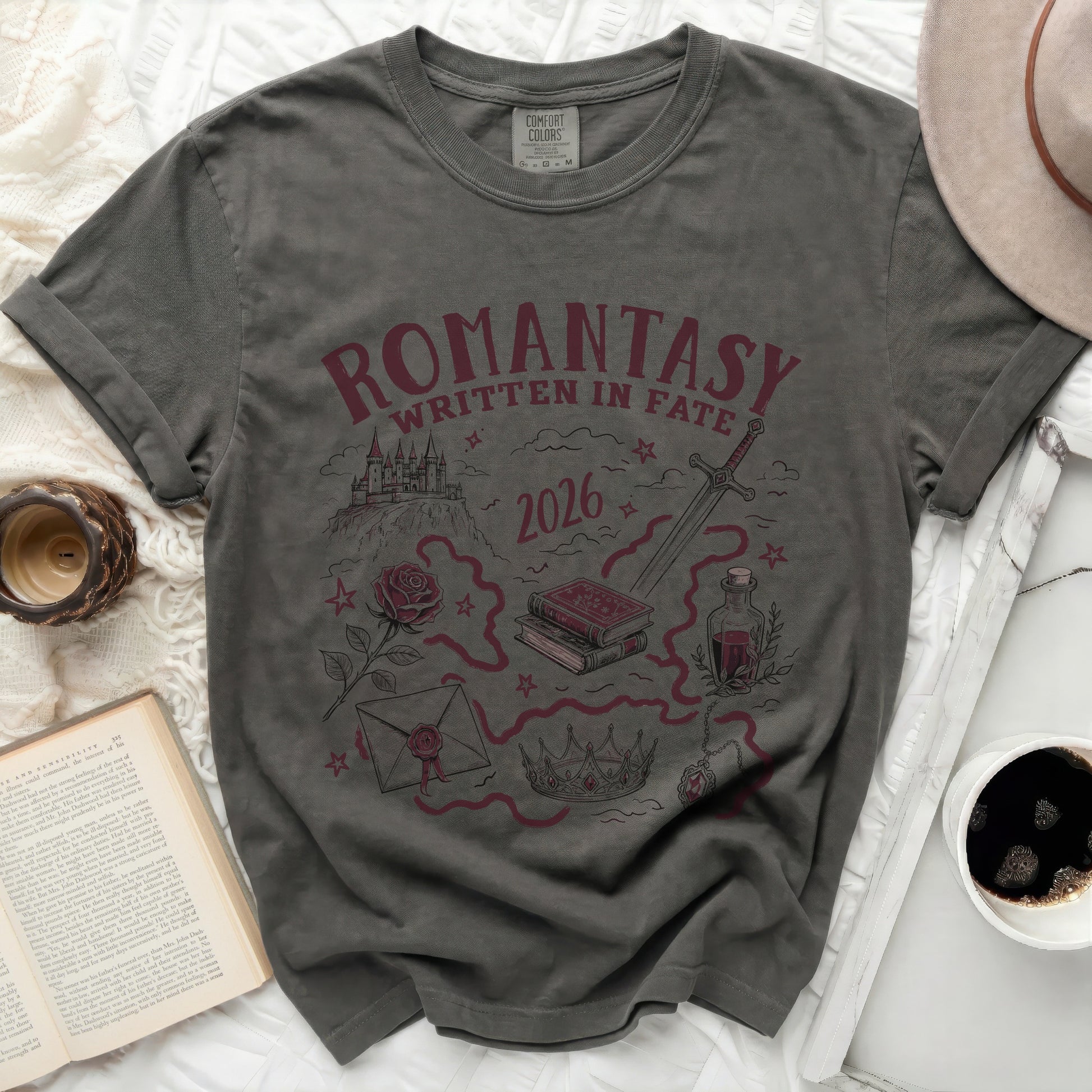 Dark grey t-shirt with "Romantasy Written in Fate 2026" and fantasy illustrations.