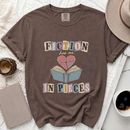 Brown t-shirt with "FICTION has me IN PIECES" text and broken heart graphic.