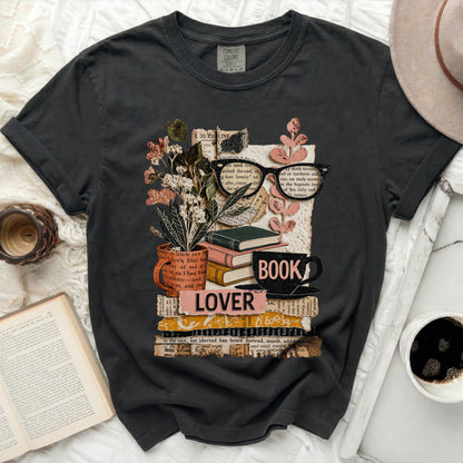 Graphic tee with stack of books, glasses, flowers, and "LOVER BOOK" text.