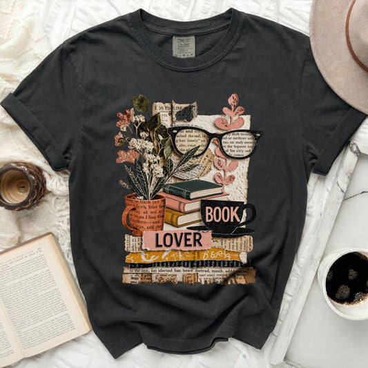 Graphic tee with stack of books, glasses, flowers, and "LOVER BOOK" text.