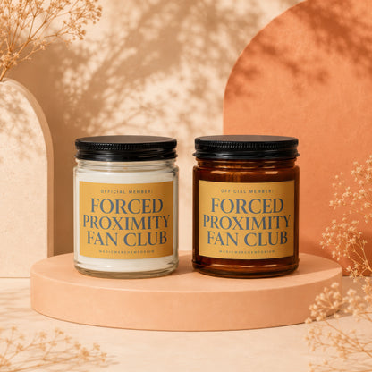Two candles, one white and one amber, labeled "Forced Proximity Fan Club".