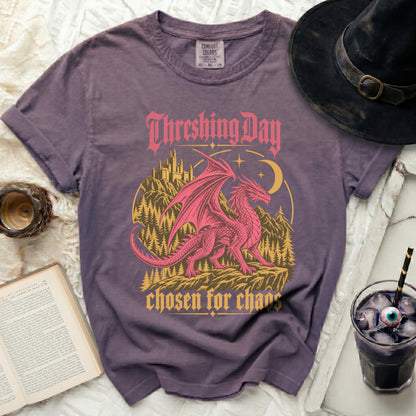 Purple t-shirt graphic with pink dragon, castle, and text "Threshing Day chosen for chaos".