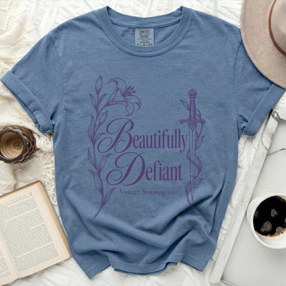 Blue t-shirt with "Beautifully Defiant Violet Sorrengail" text and floral sword graphic.