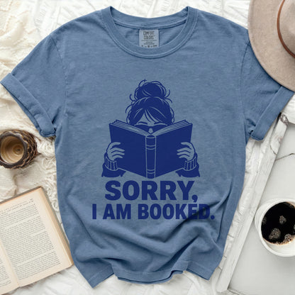 Blue t-shirt with "SORRY, I AM BOOKED." text and a graphic of a person reading.
