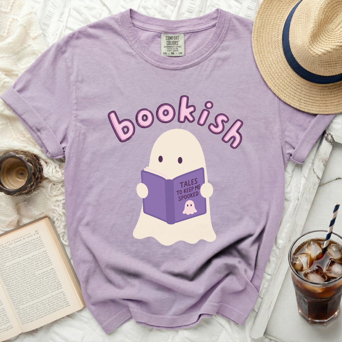 Lavender t-shirt with a cartoon ghost reading a book titled "Tales to Keep Me Spooked."
