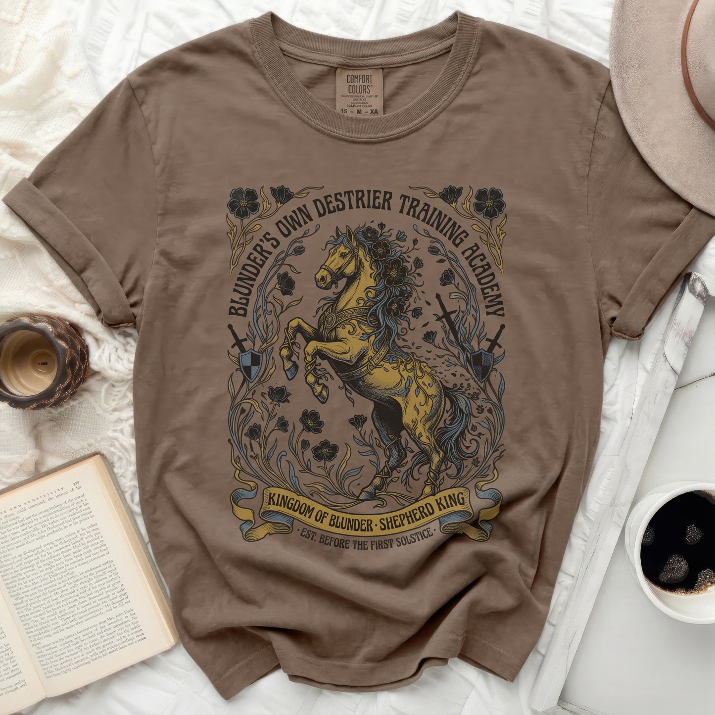 Brown t-shirt with "Blunder's Own Destrier Training Academy" unicorn graphic.