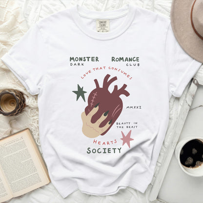White t-shirt with "Monster Dark Romance Club" text and heart graphic.