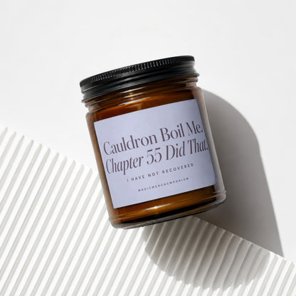 Amber glass candle with black lid, text reads: Cauldron Boil Me, Chapter 55 Did That.