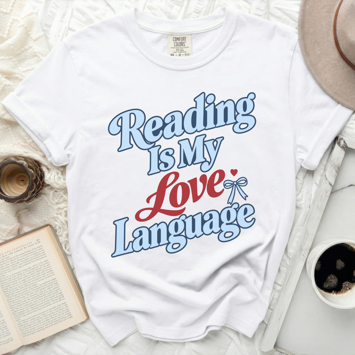 White t-shirt with "Reading Is My Love Language" text in blue and red.