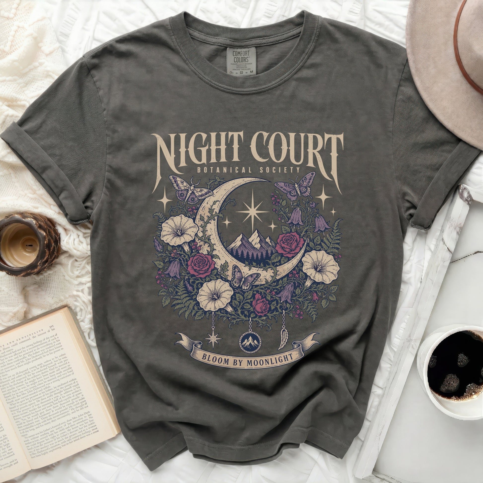 Dark grey t-shirt with moon, floral, and butterfly graphic that says "Night Court Botanical Society Bloom By Moonlight".
