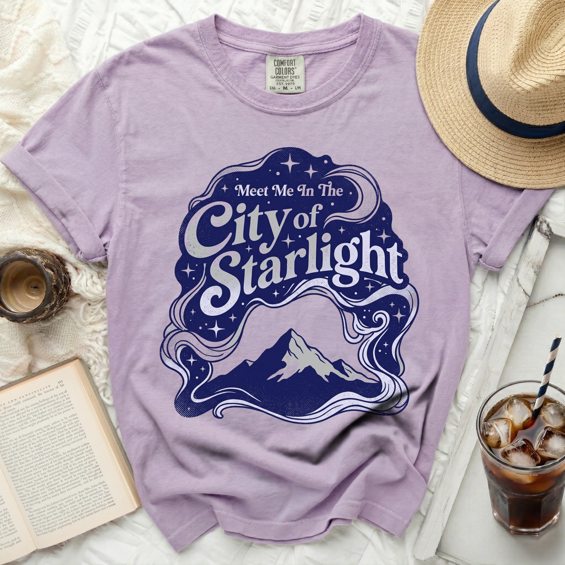 Purple t-shirt with "Meet Me In The City of Starlight" text and mountain graphic.