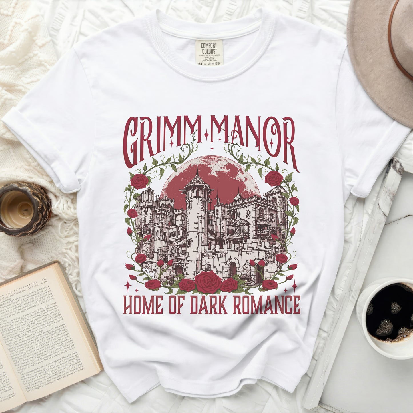 White t-shirt with "Grimm Manor Home of Dark Romance" graphic.