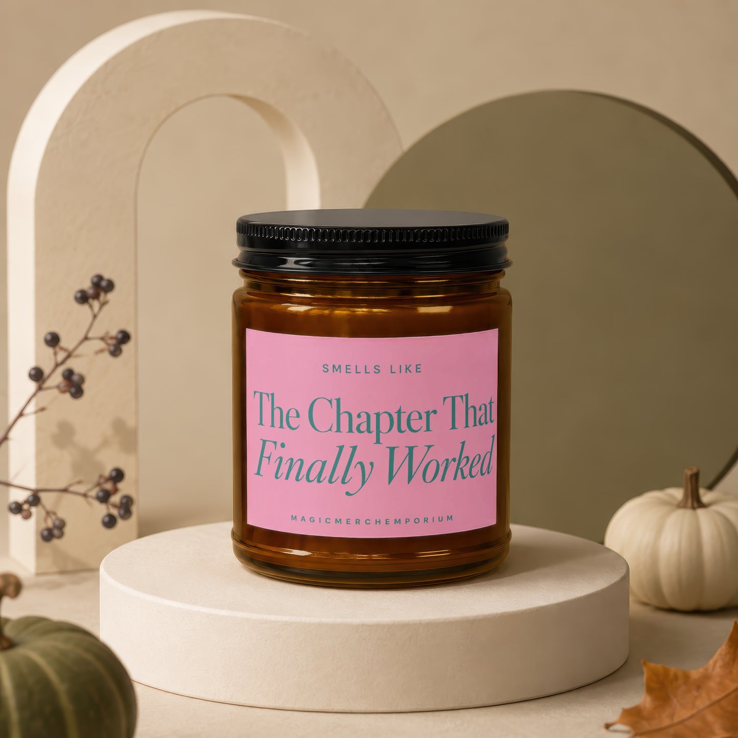 Amber glass candle with pink label reading "Smells Like The Chapter That Finally Worked"