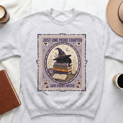 Light grey sweatshirt with a circular graphic of a black cat wearing a witch hat on books.