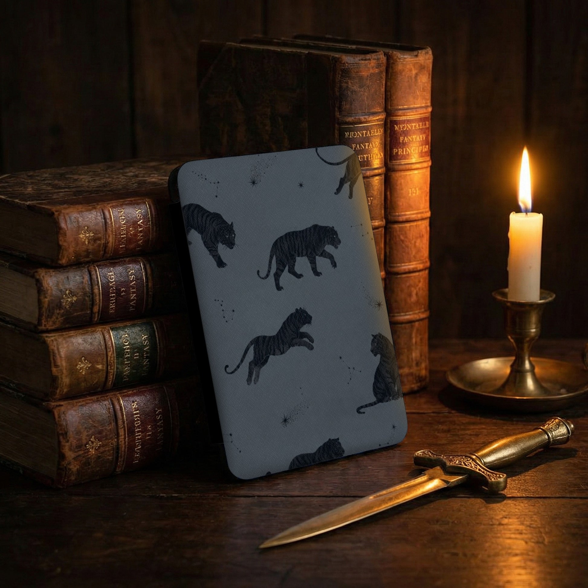 Dark gray case with black tiger and constellation print, set on wooden table.