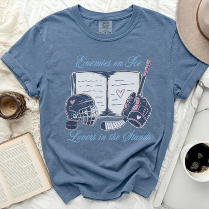 Blue t-shirt with "Enemies on Ice Lovers in the Stands" text, hockey stick, and helmet.