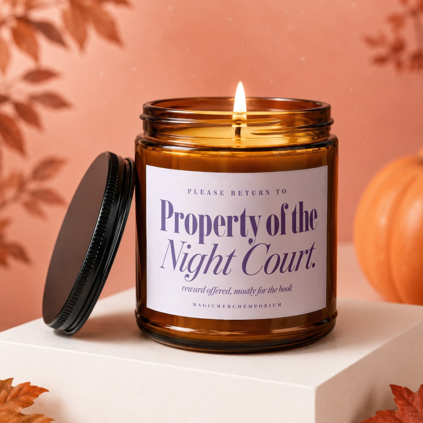 Amber jar candle with "Property of the Night Court" text, lit flame.