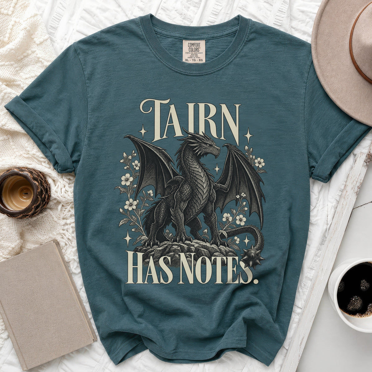 Teal t-shirt with a dragon graphic and the text "TAIRN HAS NOTES."
