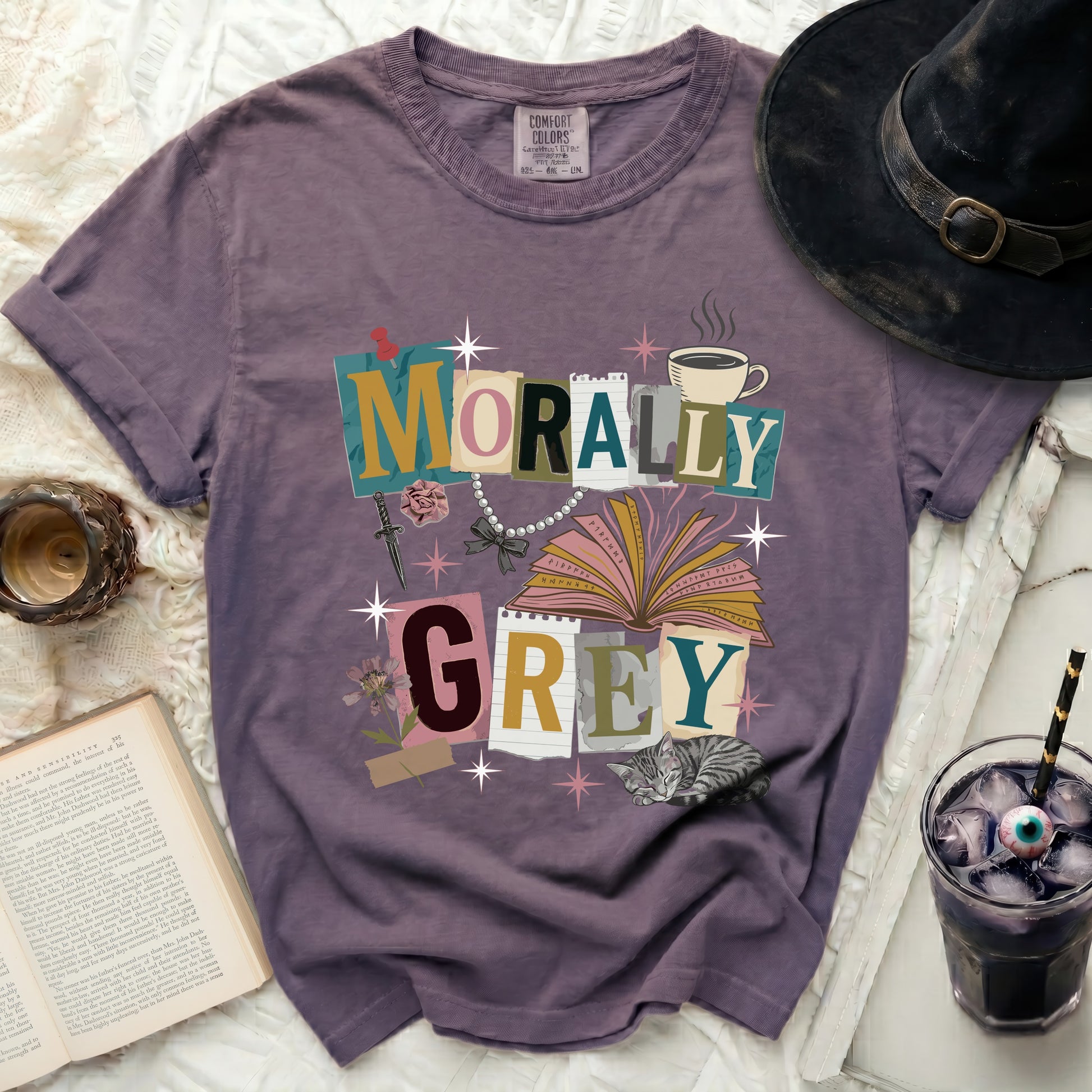 Purple t-shirt with "MORALLY GREY" text, book, sword, and cat graphic.