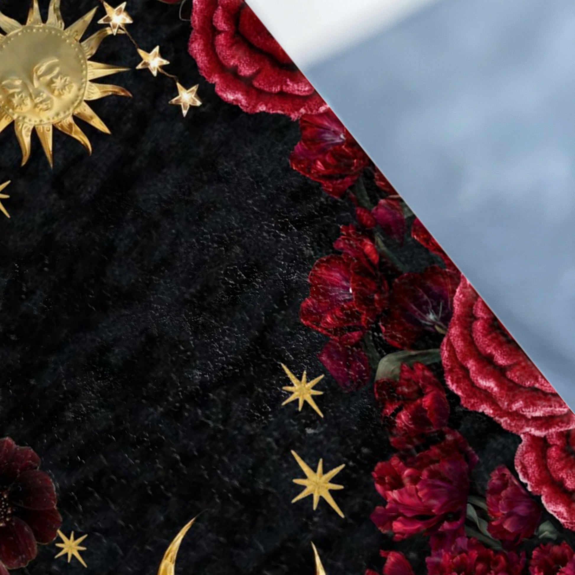 Dark background with celestial sun, stars, and red floral accents.