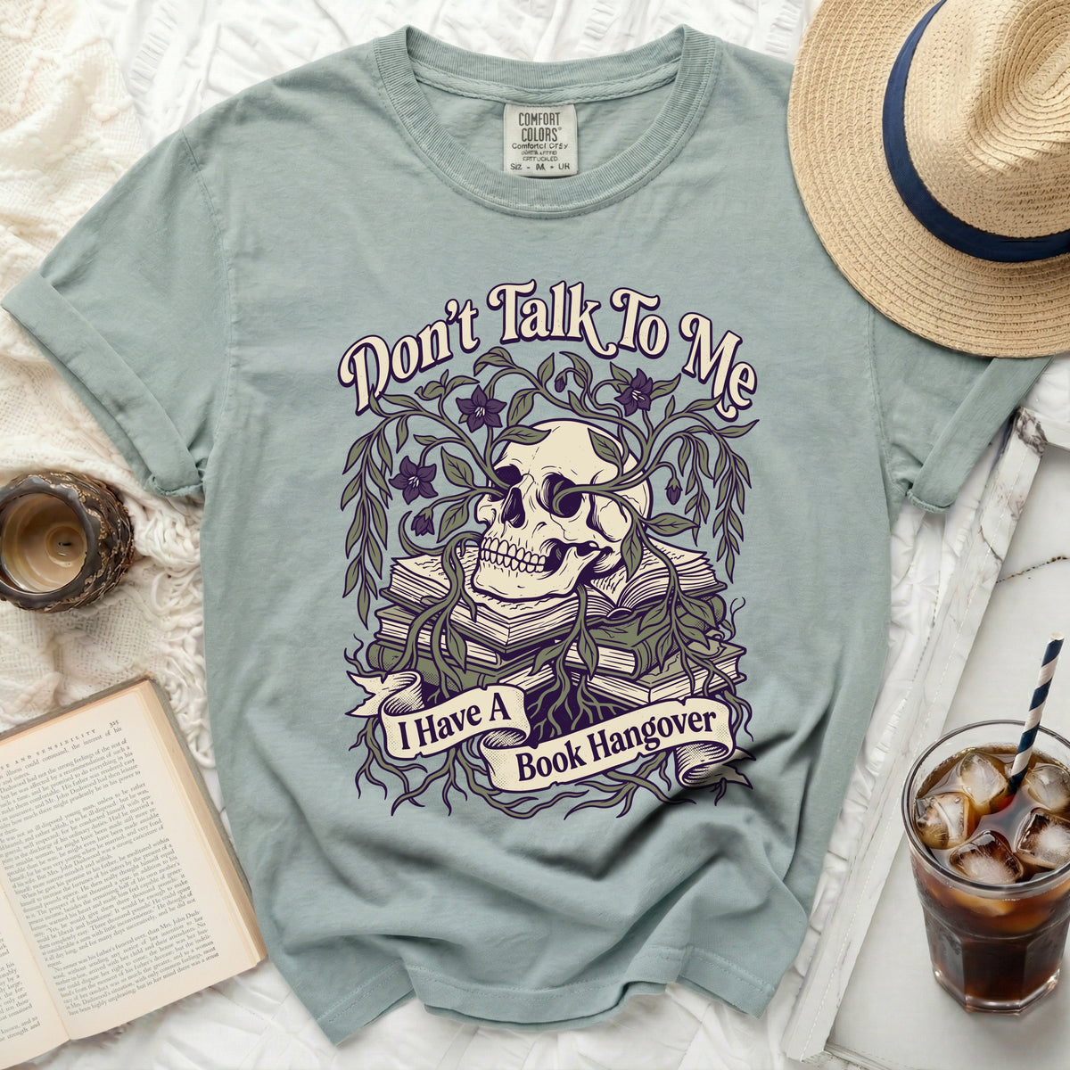 T-shirt with a skull, books, vines, and the text "Don't Talk To Me I Have A Book Hangover".