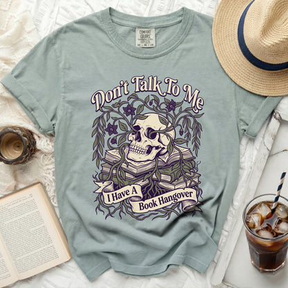 T-shirt with a skull, books, vines, and the text "Don't Talk To Me I Have A Book Hangover".